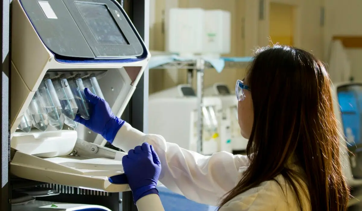 Pesquisadora operando equipamento de laboratório
